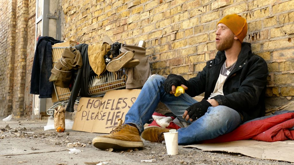 Young homeless man eating